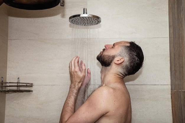 A person with their eyes closed, facing the showerhead, with water streaming down. The person appears calm and relaxed, with a serene expression on their face. The backdrop is blurred, focusing attention on the individual's peaceful state.