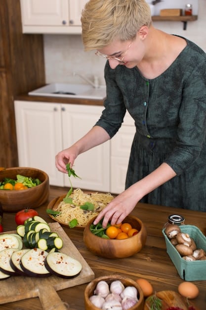 A person preparing food in a kitchen, carefully arranging ingredients on a plate. The scene is bright and inviting, with a focus on fresh, whole foods.
