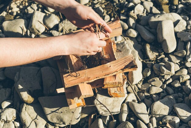 A close-up of hands carefully placing stones around the edge of a DIY fire pit, showcasing the attention to detail and craftsmanship involved in the project.