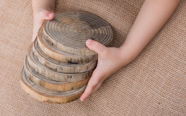 A close-up of various affordable lumber options, including pine and reclaimed wood, with price tags visible. A hand reaches out to touch the texture of a piece of wood.