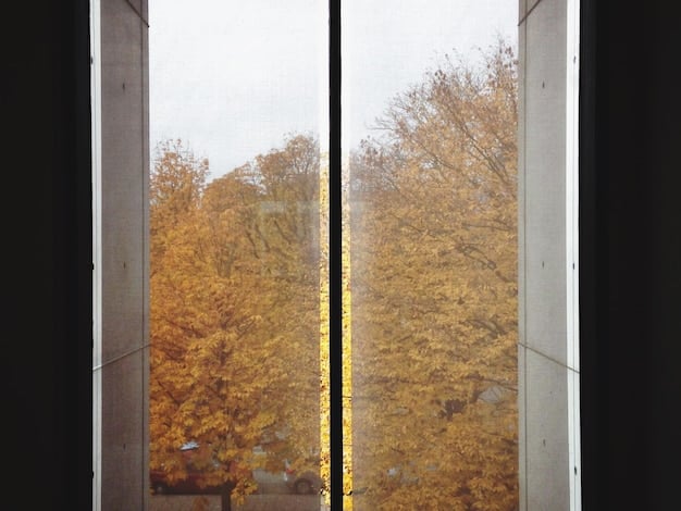 A window fully covered with insulating plastic film, neatly sealed around the edges. The reflection shows a warm interior with a lamp on.