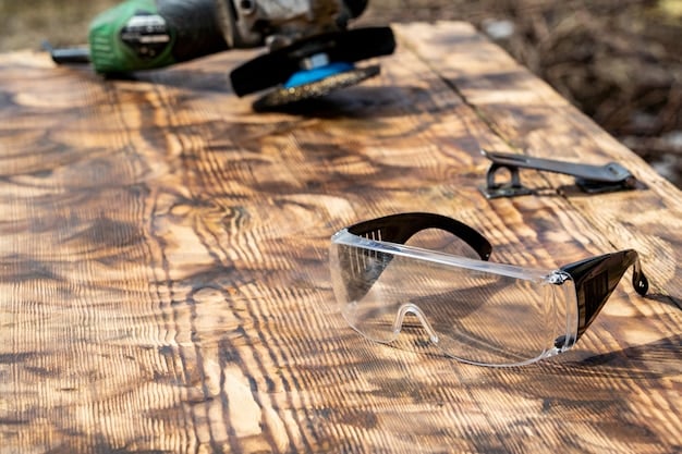 Close-up of a workbench with neatly arranged tools including a saw, drill, measuring tape, and safety glasses, with a partly assembled wooden bench in the background.