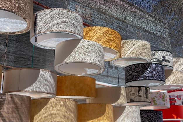 A close-up shot of various affordable materials commonly used in DIY pendant light projects, such as mason jars, wire baskets, vintage bowls, light sockets, colorful electrical cords, and different types of light bulbs.
