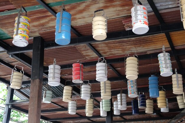 A collection of pendant lights showcasing different innovative shade designs, including one made from a vintage birdcage, another from a repurposed glass bottle, and a third wrapped in colorful yarn.